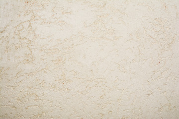 texture of the surface of the wall covered with decorative plaster of the woodworm type