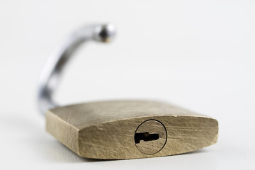 Brass padlock on a white table. Accessories for locking and securing against burglary.