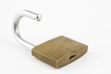 Brass padlock on a white table. Accessories for locking and securing against burglary.