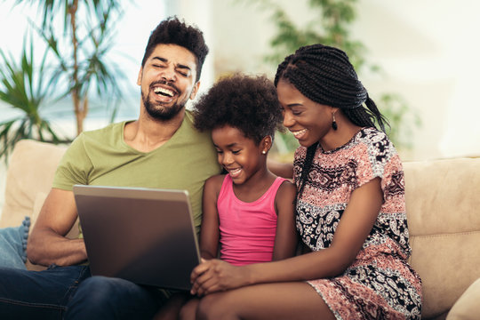 African american family using laptop in the living room.