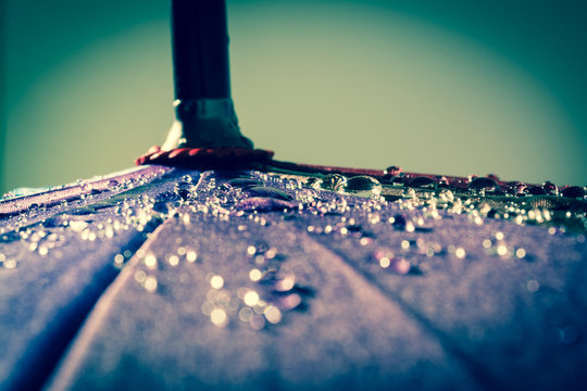 Raindrops on a colorful umbrella with all the colors of the rainbow close-up macro waterdrops background. Vintage, grunge, old, retro style photo.