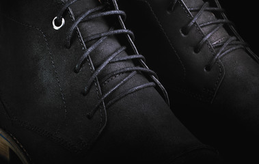 Men's black leather boots shoes laces closeup macro, black background low key
