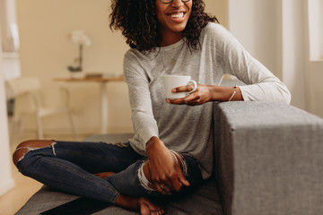 Woman enjoying a cup of coffee sitting at home