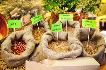italian farmer market stall with different cereals: mail (corn), grano gentilrosso (gentle red...