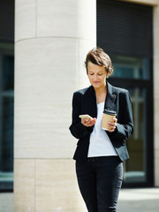 Confident formal woman using phone