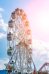 Ferris wheel on cloudy sky background