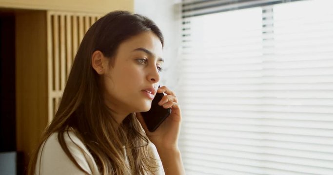 Woman talking on mobile phone in living room 4k