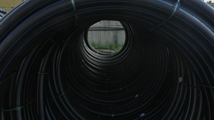 Obraz premium Warehouse of finished plastic pipes industrial outdoors storage site. Manufacture of plastic water pipes factory. Process of making plastic tubes on the machine tool with the use of water and air