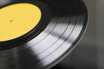 Gramophone plate with a yellow sticker. Traks. Closeup. Bokeh.