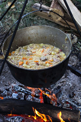 A pot of meat over a fire. Hike, summer vacation, outdoor recreation, outdoor food.