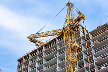 Construction site with cranes and building with blue sky