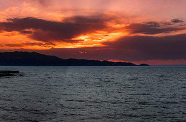 sunset at the sea with a view of the mountains in Heraklion Crete