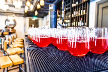 Glasses of red juice or lemonade are on the bar.