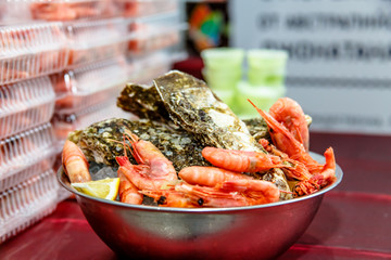 Shrimp and oysters are in an iron bowl.