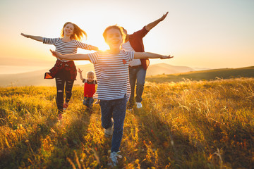 Happy family: mother, father, children son and daughter on sunset