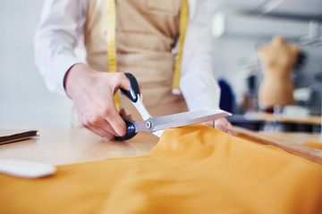 Tailor cutting orange cloth