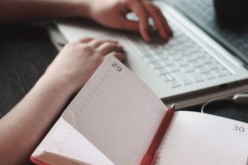 Empty notebook and laptop keyboard closeup