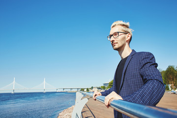 Fototapeta premium Handsome man resting at�quay�handrail