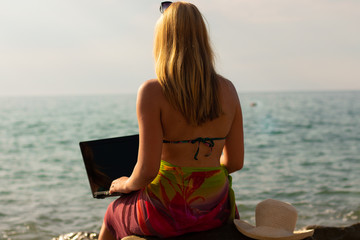 Fototapeta na wymiar girl working with laptop on the sea
