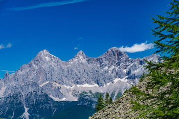 Fototapeta premium Hohe Dachstein pasmo górskie w Austria z zielonymi drzewami na przedpolu