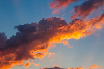 Colorful red and orange fluffy clouds at blue sky in sunset time, beautiful nature cloudscape