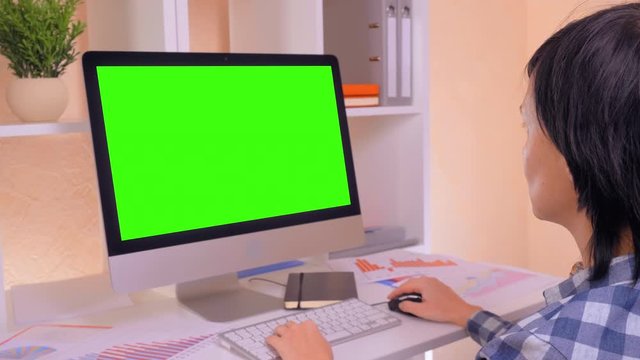 businesswoman working on computer. workplace with white desk folders financial schedule and charts using pc mouse and keyboard shortcuts display with isolated green screen