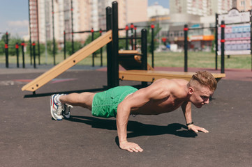 Sports man on the street Playground engaged in sports and push-UPS from the floor - 212826458