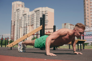 Sports man on the street Playground engaged in sports and push-UPS from the floor - 212826471
