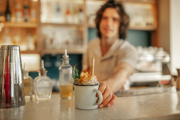 Bartender serving drinks behind the counter of a trendy bar