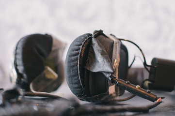 Broken headphones on the wooden table with sellotape closeup