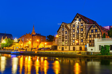 Fototapeta na wymiar The waterfront on the river Brda with famous granaries at night in Bydgoszcz, Poland