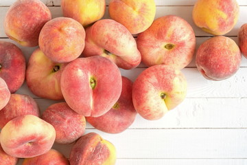 Ripe juicy peaches on a wooden white background. Fruit summer background. Flat lay, top view, copy space 