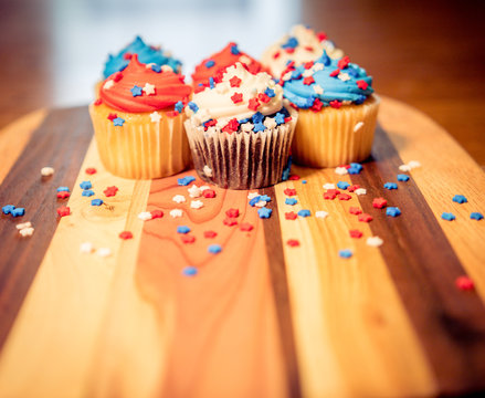 Red, White, And Blue Cupcakes On Wooden Board