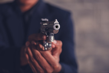 Mafia man holding a gun to intimidate