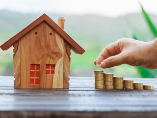 coin stack with house model, savings plans for housing ,financial concept