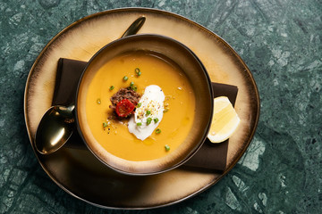 Lentil cream soup with baked lamb, cream fresh and spearmint. Delicious healthy soup food in bowl...