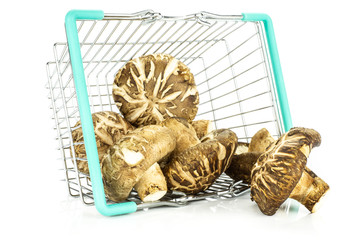 Fresh raw brown shiitake mushroom out of a shopping basket isolated on white.