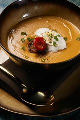 Hot Lentil cream soup with baked lamb, cream fresh and spearmint. Delicious healthy soup food in bowl plate on table background, close-up, top view