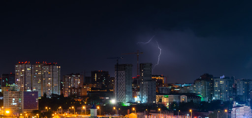 Obraz premium Thunder, lighting and storm in dark night sky above city