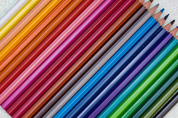 Colored pencils on diagonal on white glitter background II