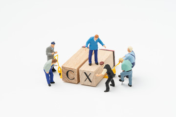 Customer Experience concept, miniature workers or creative team help building cube wooden block...