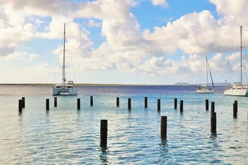 Fototapeta na wymiar Sailboats on the ocean with pilings