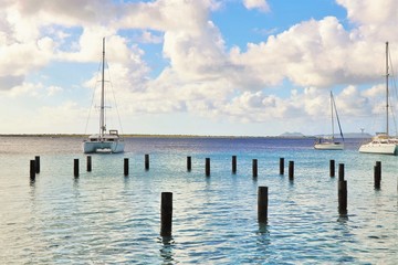 Fototapeta premium Sailboats on the ocean with pilings