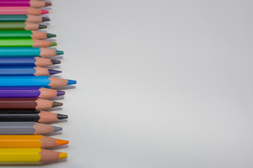 Colored pencils on the left side horizontal, white background