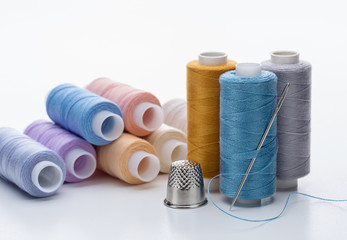 Threads of different colors for needlework.  Thimble and  needle.