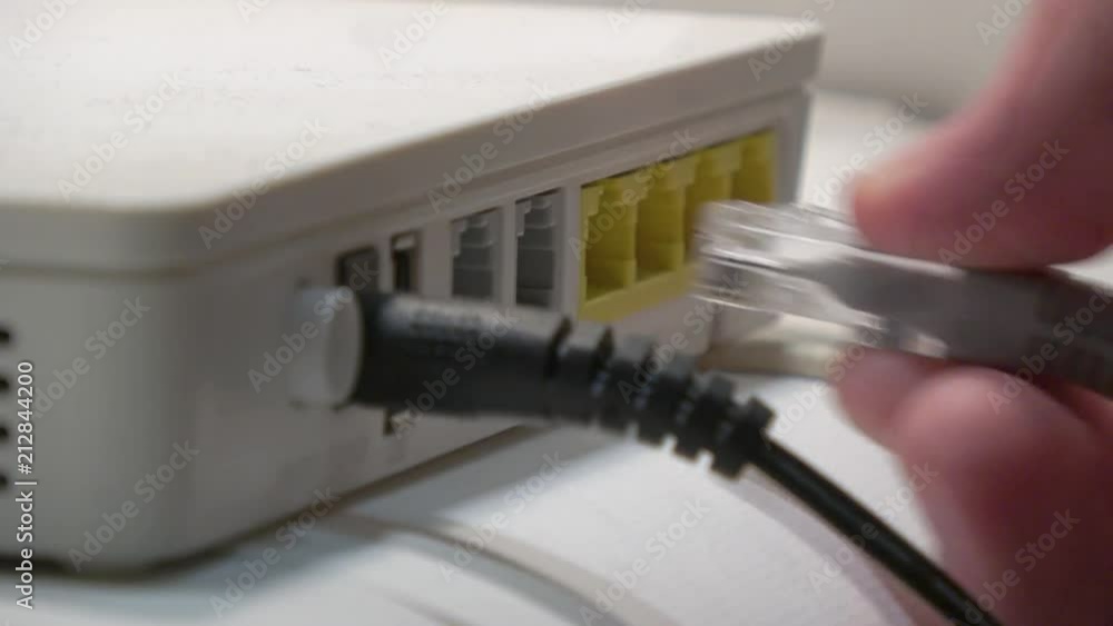 Poster plugging and unplugging ethernet cable from router - detail