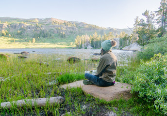 Girl Sitting on Rock Looking at Beautiful Mountain Lake