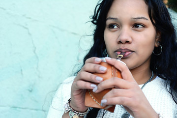 Young latin woman drinking traditional yerba mate tea.