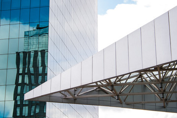 Glass windows reflect the sky in business buildings with modern metallic architectural details.