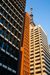 Fototapeta premium A television antenna is placed on the roof of a corporate white building with blue sky on the background.